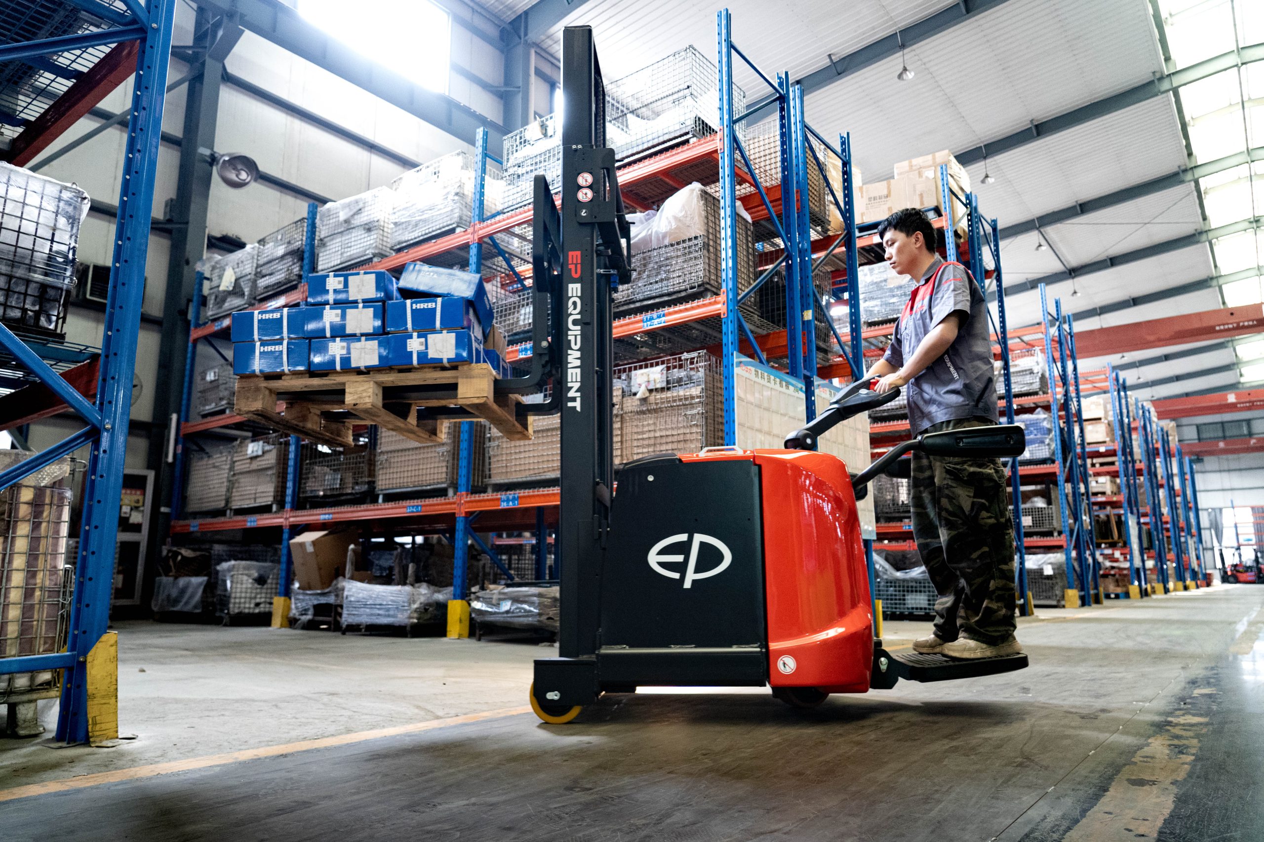 ES16-RS/RSI electric ride-on pallet stacker being operated with a operator riding on it.