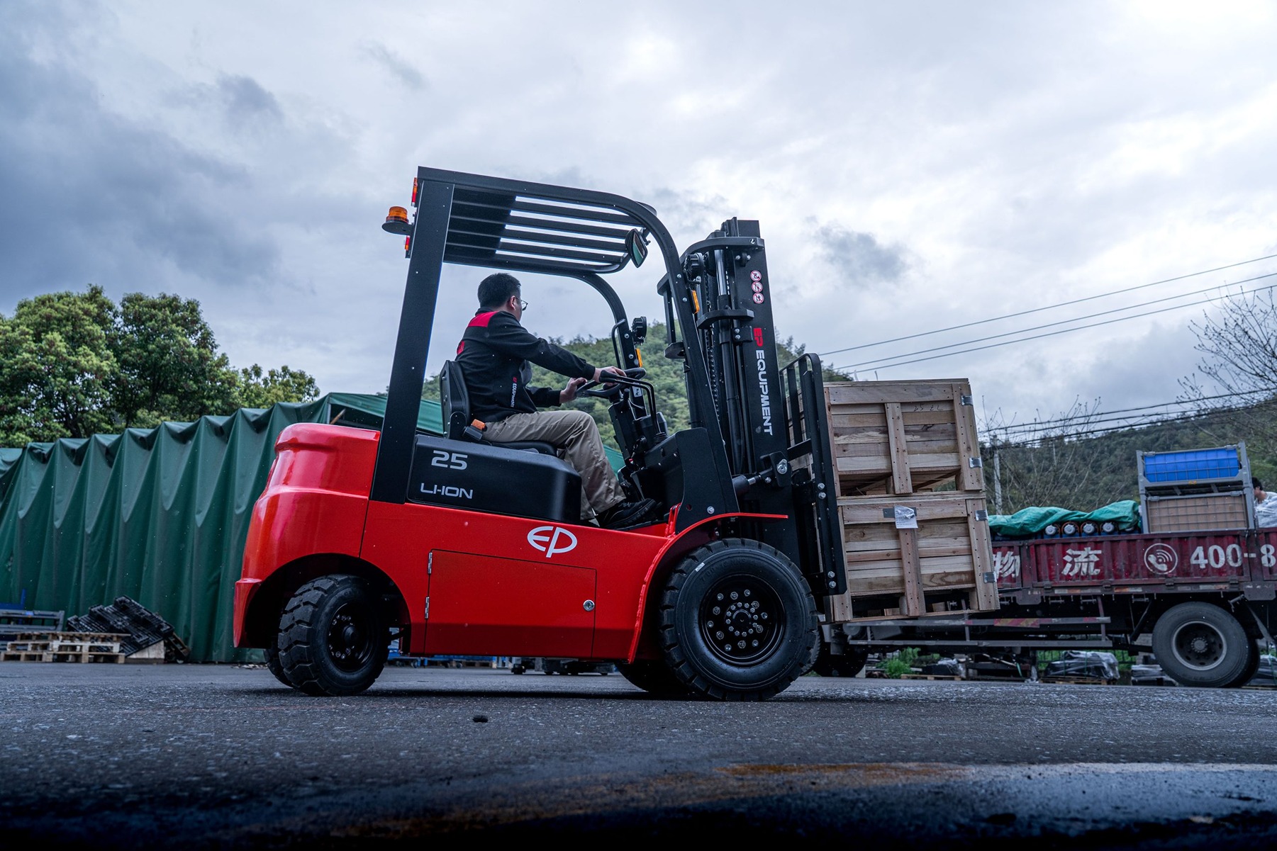EFL252X forklift truck transporting loads in outdoor environment.